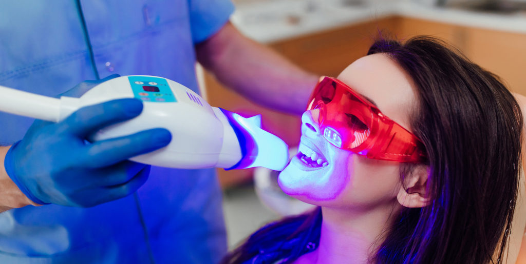 Teeth whitening for woman. Bleaching of the teeth at dentist clinic.