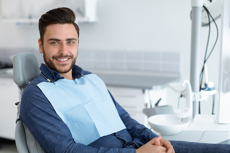 Young man patient smiling in dentistry, copy space
