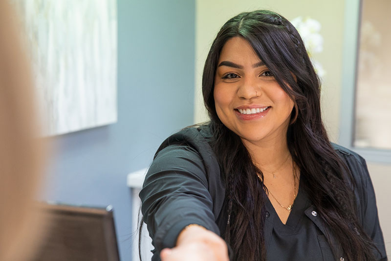 Staff member helping patient at the front desk of the dental office